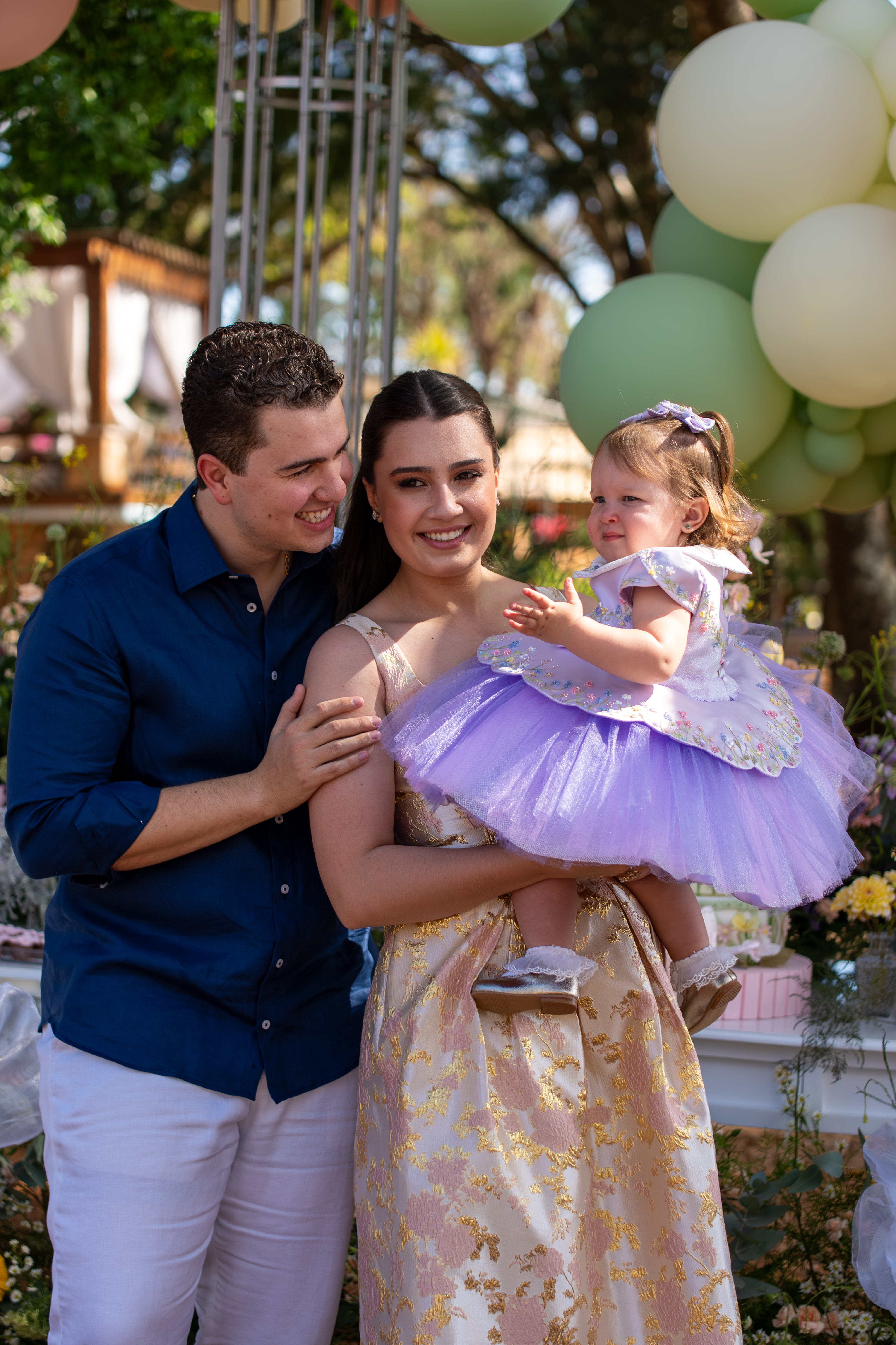 Família com a filha na festa, cercada de balões