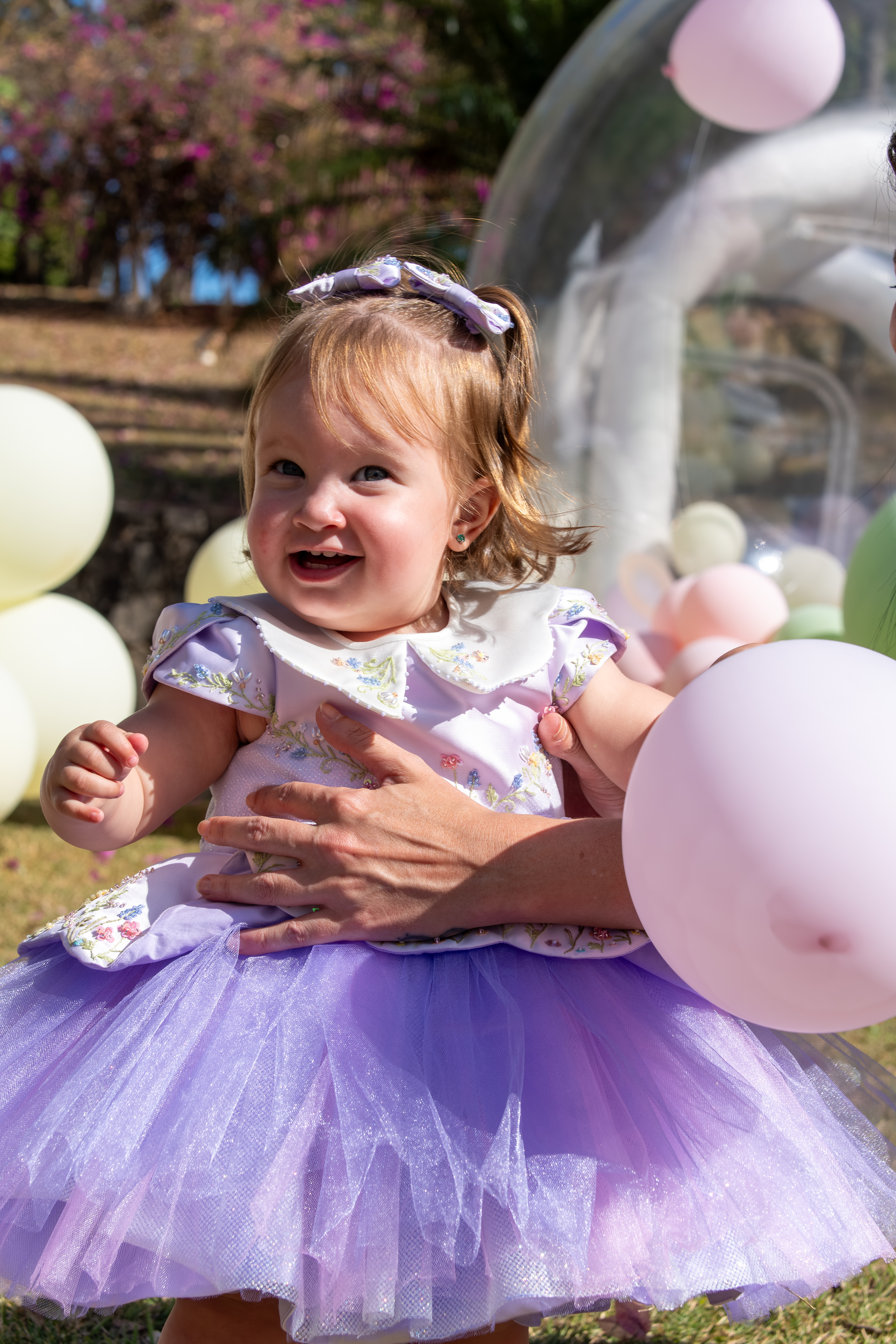 Menininha sorrindo na festa, em vestido lilás